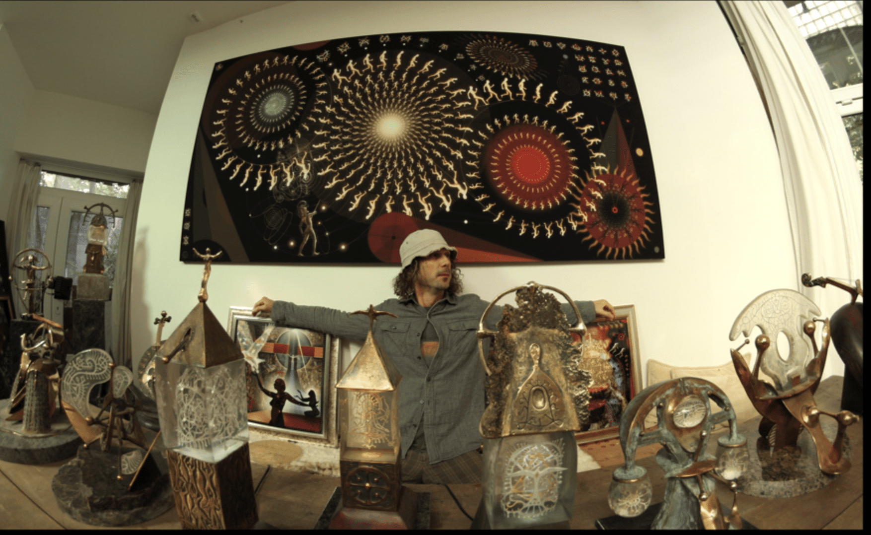 Man posing with art prints and sculptures